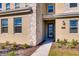 Inviting home entrance featuring a blue glass-paneled door, stone accents, and neatly landscaped garden beds at 2859 Bookmark Dr, Kissimmee, FL 34746