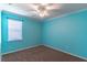 Bedroom with brown carpet, white trim, fan and light fixture, window and blue walls at 4770 Cypress Forest Ln, St Cloud, FL 34772