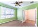 Green bedroom featuring large window, ceiling fan, plush carpet and glass panel French doors at 4770 Cypress Forest Ln, St Cloud, FL 34772