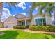 Charming single-story home with a three-car garage, brick paver driveway, and lush, manicured landscaping at 4770 Cypress Forest Ln, St Cloud, FL 34772