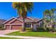 Charming single-story home featuring a manicured lawn, tropical palm trees, and a two-car garage at 4770 Cypress Forest Ln, St Cloud, FL 34772