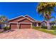 Beautiful home showcasing brick paved driveway, manicured lawn, and a two-car garage at 4770 Cypress Forest Ln, St Cloud, FL 34772