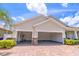 Exterior shot showcasing attached garage, painted concrete floors, brick paver driveway, and manicured landscaping at 4770 Cypress Forest Ln, St Cloud, FL 34772