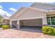 Attached two car garage showing neutral paint and epoxy floors and brick paver driveway for extra curb appeal at 4770 Cypress Forest Ln, St Cloud, FL 34772