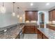 Open kitchen with granite countertops, wooden cabinets, and a stainless steel dishwasher at 4770 Cypress Forest Ln, St Cloud, FL 34772