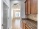View of granite countertops and cabinets, leading to a living area with a chandelier and large window at 4770 Cypress Forest Ln, St Cloud, FL 34772