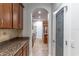 Galley style kitchen with dark wood cabinets, granite countertops, tile floor, and pantry with glass door at 4770 Cypress Forest Ln, St Cloud, FL 34772