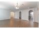 Spacious living room featuring elegant chandelier, tile flooring, and arched doorways at 4770 Cypress Forest Ln, St Cloud, FL 34772