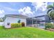 Backyard view of a screened-in pool area with well-maintained landscaping and a lush green lawn at 4770 Cypress Forest Ln, St Cloud, FL 34772