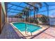 Backyard pool with pool enclosure, brick decking, palm trees, and views of rear yard at 4770 Cypress Forest Ln, St Cloud, FL 34772