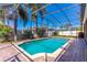 Backyard pool with pool enclosure, brick decking, and landscaping in a tropical environment at 4770 Cypress Forest Ln, St Cloud, FL 34772