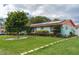 Landscaped front lawn of a home featuring a healthy tree, bushes, and solar panels on the roof at 4792 Indian Gap Dr, Orlando, FL 32812