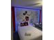 Vibrant bedroom with decorative Mickey Mouse wall art and twin beds, illuminated with neon lighting at 4949 Windermere Ave, Kissimmee, FL 34746