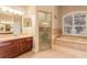 Well-lit bathroom featuring double vanity sinks, a soaking tub, and glass enclosed shower at 5543 Grey Hawk Ln, Lakeland, FL 33810