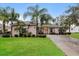 Stunning single-story home featuring a well-manicured lawn, mature palm trees, and a welcoming double door entrance at 5543 Grey Hawk Ln, Lakeland, FL 33810