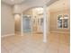 Inviting foyer features tiled flooring, white columns, and a decorative chandelier above a glass-paneled front door at 5543 Grey Hawk Ln, Lakeland, FL 33810