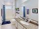 A well-lit bathroom featuring granite countertops, an undermount sink, a large mirror, and a shower-tub combination at 607 Black Eagle Dr, Groveland, FL 34736