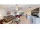 Open-concept living room with tile flooring, modern chandelier, tv, and lots of seating facing the open kitchen at 607 Black Eagle Dr, Groveland, FL 34736