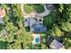 An aerial view of the property, showing the pool, lush landscaping, and circular driveway at 6115 Linneal Beach Dr, Apopka, FL 32703