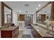 Elegant bathroom featuring a stone shower, granite counters, and decorative mirrors at 6115 Linneal Beach Dr, Apopka, FL 32703