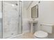 Bathroom featuring a glass shower, wall mirror, pedestal sink, and toilet on a tile floor at 6155 Hedgesparrows Ln, Sanford, FL 32771