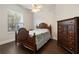 Cozy bedroom featuring a dark wood bed frame, ceiling fan, and natural light from the window at 6155 Hedgesparrows Ln, Sanford, FL 32771