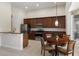 Traditional-style kitchen featuring dark wood cabinetry, stainless steel appliances, granite countertops, and a cozy dining area at 6155 Hedgesparrows Ln, Sanford, FL 32771