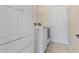 Modern laundry room featuring a washer and dryer, white cabinetry, and a tiled floor at 6155 Hedgesparrows Ln, Sanford, FL 32771