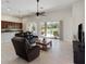 Bright living room boasts sliding glass doors to pool area, leather furniture, and tiled floors at 6155 Hedgesparrows Ln, Sanford, FL 32771