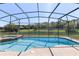 Screened pool with integrated spa and view of the lake and lush backyard at 6155 Hedgesparrows Ln, Sanford, FL 32771