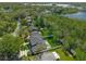 Aerial view of the home, property, and wooded area with a large lake in the background at 640 Old Horatio Ave, Maitland, FL 32751