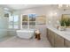 Bright bathroom features a modern soaking tub, walk-in shower, and vanity with double sinks at 640 Old Horatio Ave, Maitland, FL 32751