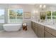 Bright bathroom with large tub, double sink vanity, neutral tiling, and ample counter space at 640 Old Horatio Ave, Maitland, FL 32751