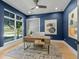 Cozy home office with navy blue walls, a modern desk, and a large window with a view of the outdoors at 640 Old Horatio Ave, Maitland, FL 32751