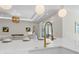 Close-up of a kitchen island with a white countertop and a golden faucet, with the living room in the background at 640 Old Horatio Ave, Maitland, FL 32751