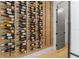 Close-up of a wine room with a wood panel wall featuring black metal wine racks and a variety of wine bottles at 640 Old Horatio Ave, Maitland, FL 32751