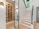 Stylish wine room featuring a wood panel wall with black wine racks and a glass door, adjacent to the staircase at 640 Old Horatio Ave, Maitland, FL 32751