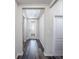 Hallway with wood-look flooring, neutral walls, and a glass-accented front door at 6471 Octave St, Mascotte, FL 34753