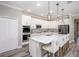 This modern kitchen features a large island with barstool seating and stainless steel appliances at 6471 Octave St, Mascotte, FL 34753