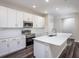 Modern kitchen featuring white cabinetry, stainless steel appliances, and a center island with quartz countertops at 6471 Octave St, Mascotte, FL 34753