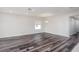 Minimalist living room featuring wood-look floors, bright natural light, and a modern chandelier at 6471 Octave St, Mascotte, FL 34753