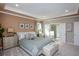 Serene main bedroom with tray ceiling, plush carpet, and large windows offering a peaceful view at 6471 Octave St, Mascotte, FL 34753