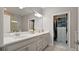 Bathroom with double sink vanity, granite counters, and custom closet organization at 652 Orange Belt Loop, Winter Garden, FL 34787