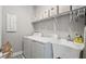 Bright laundry room featuring a sink, washer, dryer, and shelving for organizing supplies at 652 Orange Belt Loop, Winter Garden, FL 34787