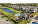 Aerial view of community swimming pool, sun loungers, landscaping, and pond in a fenced-in neighborhood at 652 Orange Belt Loop, Winter Garden, FL 34787