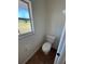 Neutral bathroom with tile floors, a toilet next to the window, and a bright, sunny view to the outdoors at 7847 Golf Paradise Way, Clermont, FL 34711