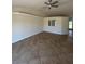 Large, neutral living room with ceramic tile floors, a cut-out feature to the kitchen, and a ceiling fan at 7847 Golf Paradise Way, Clermont, FL 34711