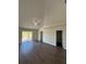 A bright main bedroom featuring wood-look floors, a ceiling fan, and sliding glass doors to the outside at 7847 Golf Paradise Way, Clermont, FL 34711