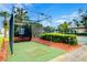 Golf cage surrounded by landscaping and palm trees near other community amenities at 8819 Dunes Ct # 208, Kissimmee, FL 34747