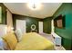 Comfortable Main Bedroom featuring a bed with bright yellow bedding, dark-green walls, and convenient TV viewing at 8819 Dunes Ct # 208, Kissimmee, FL 34747